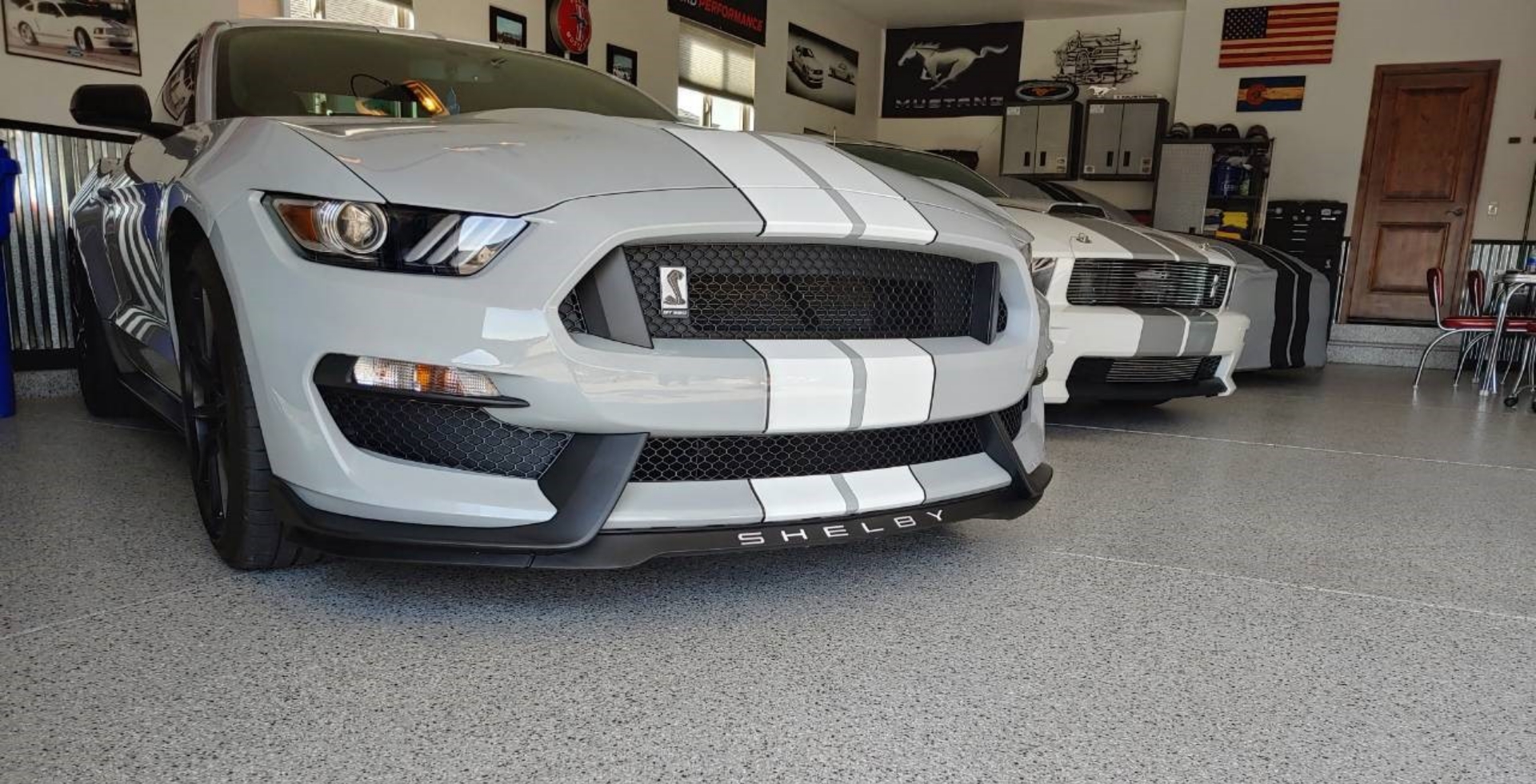 clean garage with several shelby cobra cars