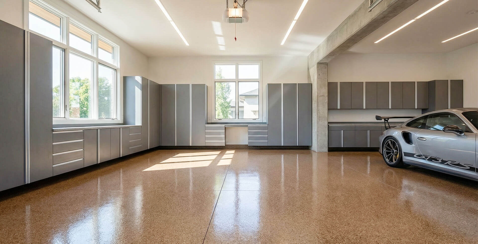 clean garage with epoxy flooring and storage featuring a car