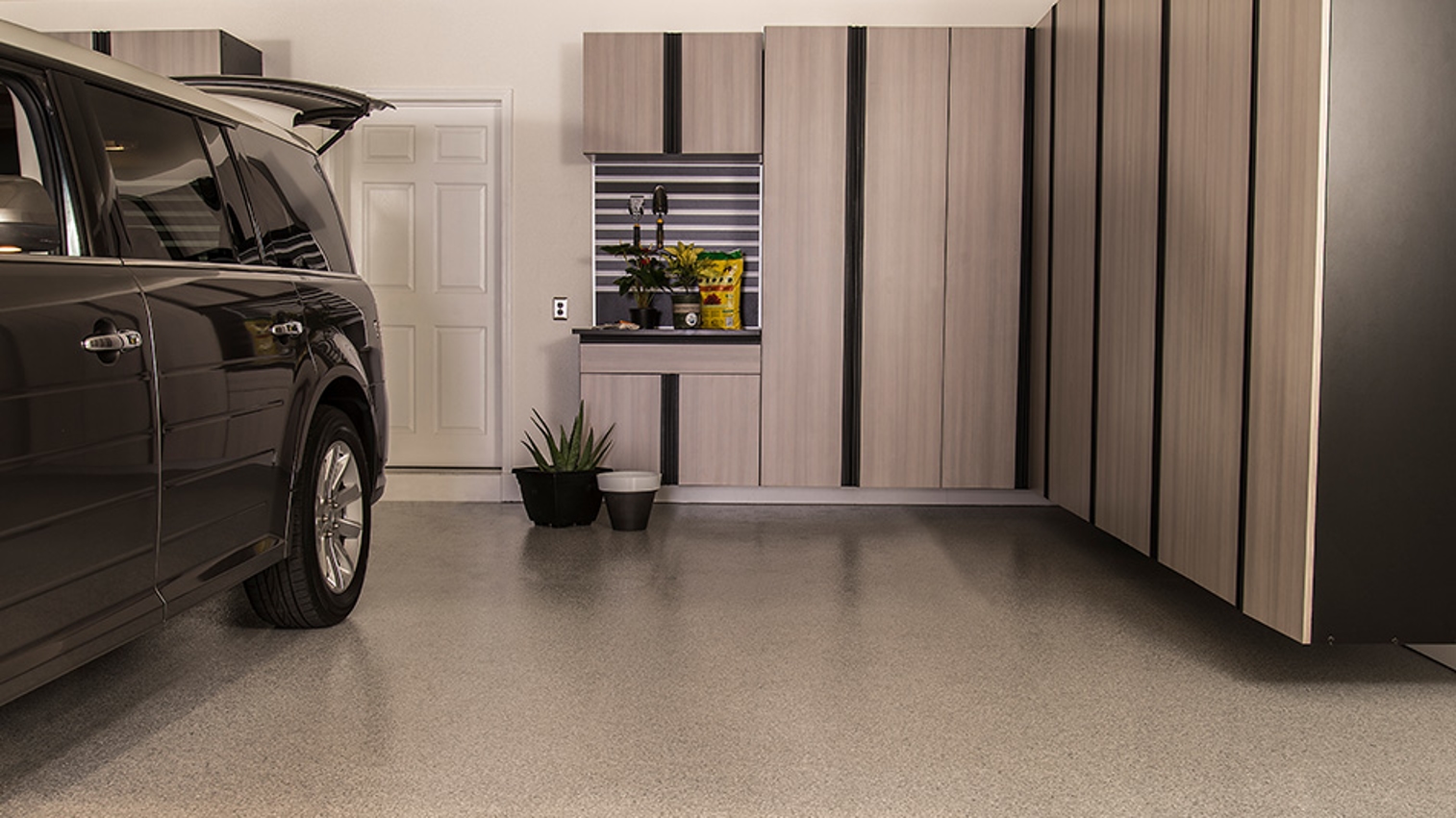 man standing in garage with suv and epoxy flooring