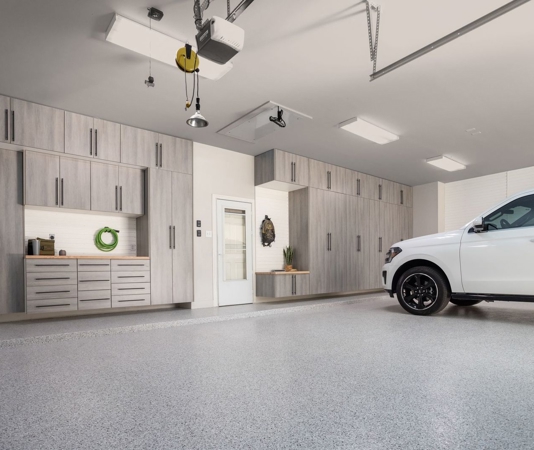 Garage with dusk haven cabinets and white car.
