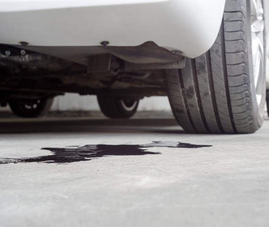 Engine oil leaking from car onto concrete floor
