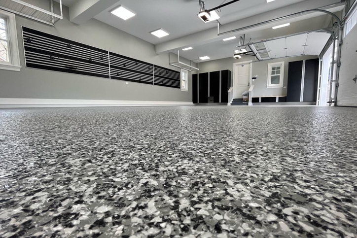 Residential garage with epoxy floor coating and decorative flake finish, gray and black color blend.