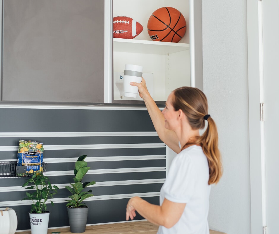 woman putting up cup in storage
